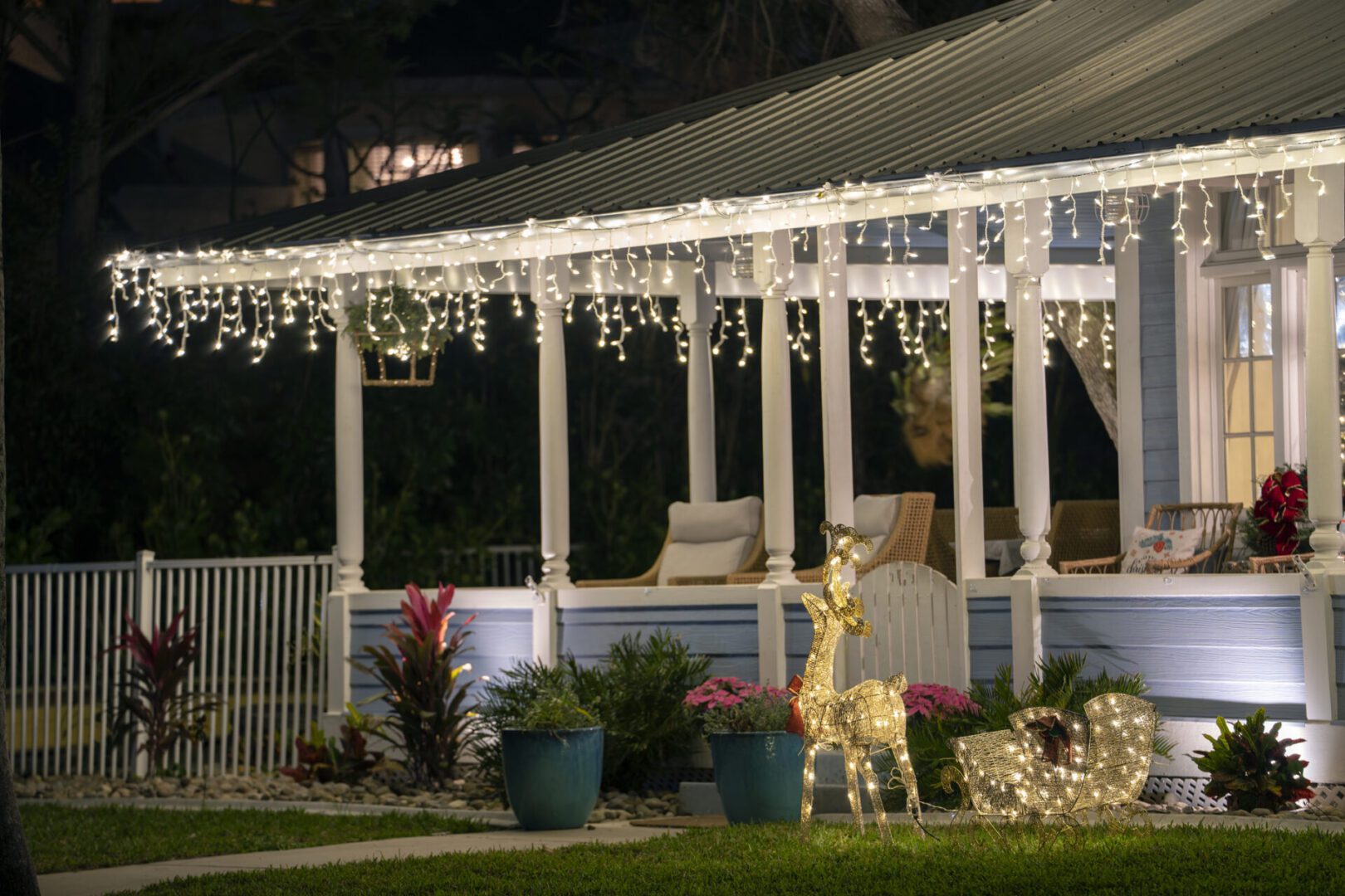 Holiday lights adorn cozy porch at night.