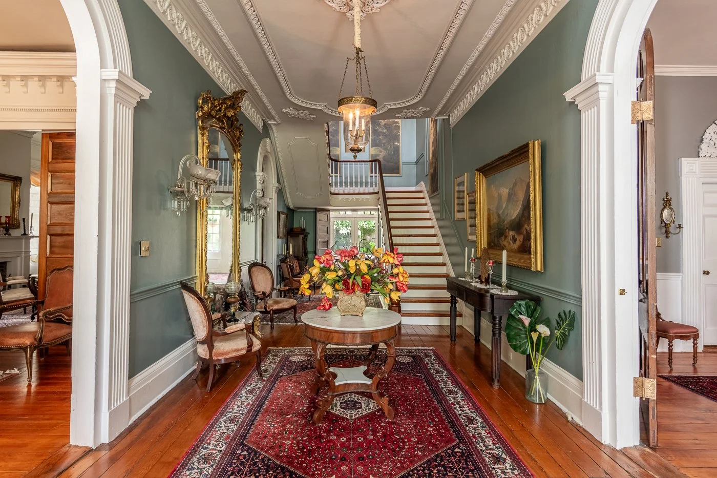 Elegant foyer with classic furniture and a grand staircase.