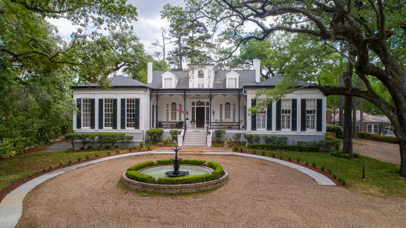 Elegant southern mansion with a circular driveway and manicured garden.