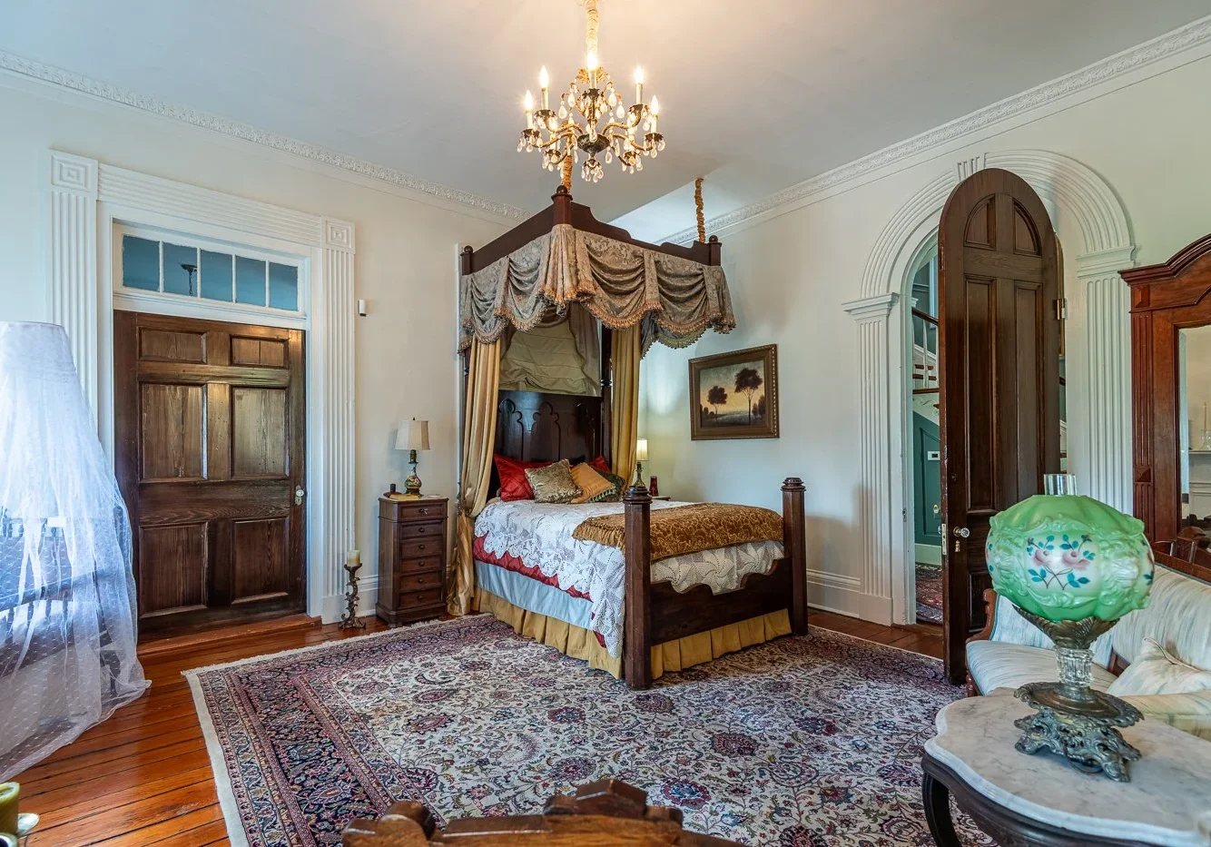 Elegant vintage bedroom with a canopy bed and chandelier.