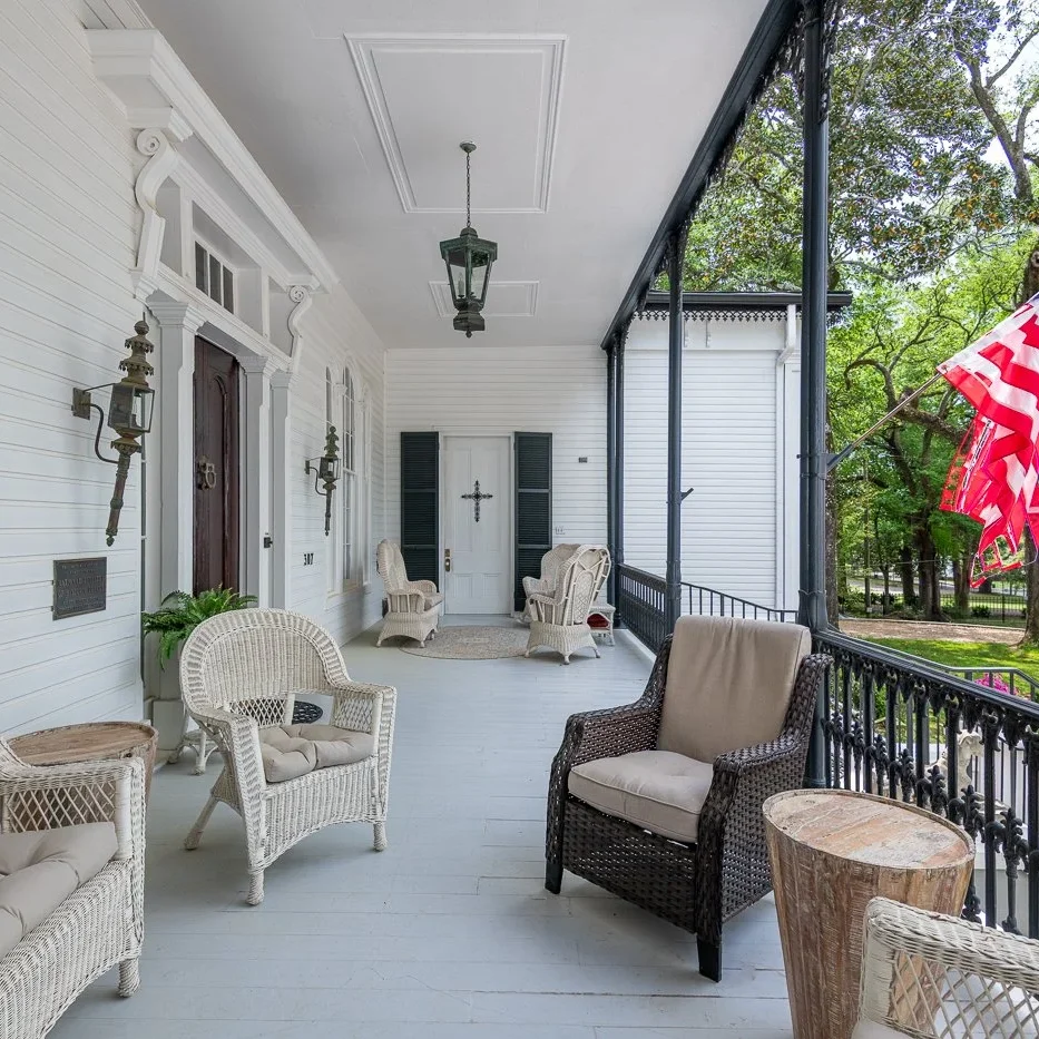 Cozy porch with wicker chairs and American flag.